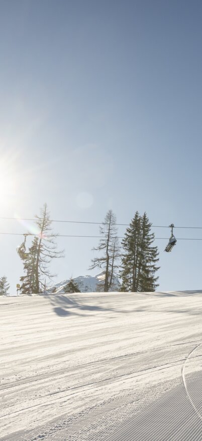 Skifahrer fährt im Sonnenschein die bestens präparierten Pisten der Reiteralm hinunter. | © Lorenz Masser